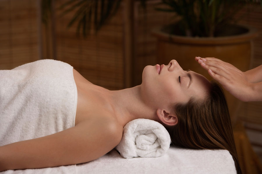 A woman lies peacefully on a spa bed with a towel wrapped around her