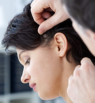 Woman having her hairline checked by an expert