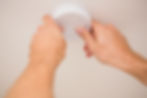 Handyman installing a smoke detector on the ceiling
