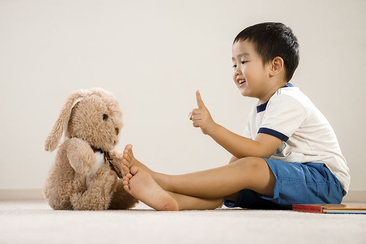 Asian boy playing with his rabbit plush toy