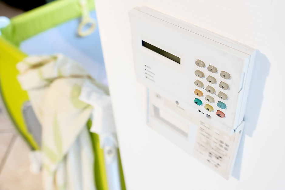 A white security alarm on a wall