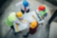 Construction workers and architects working on construction site