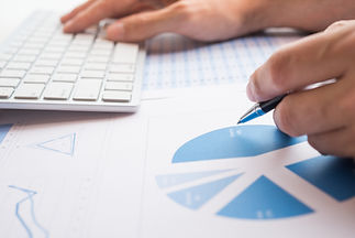Close-up of hands analyzing pie chart data