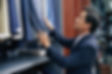 Asian man picking a suit in a menswear shop