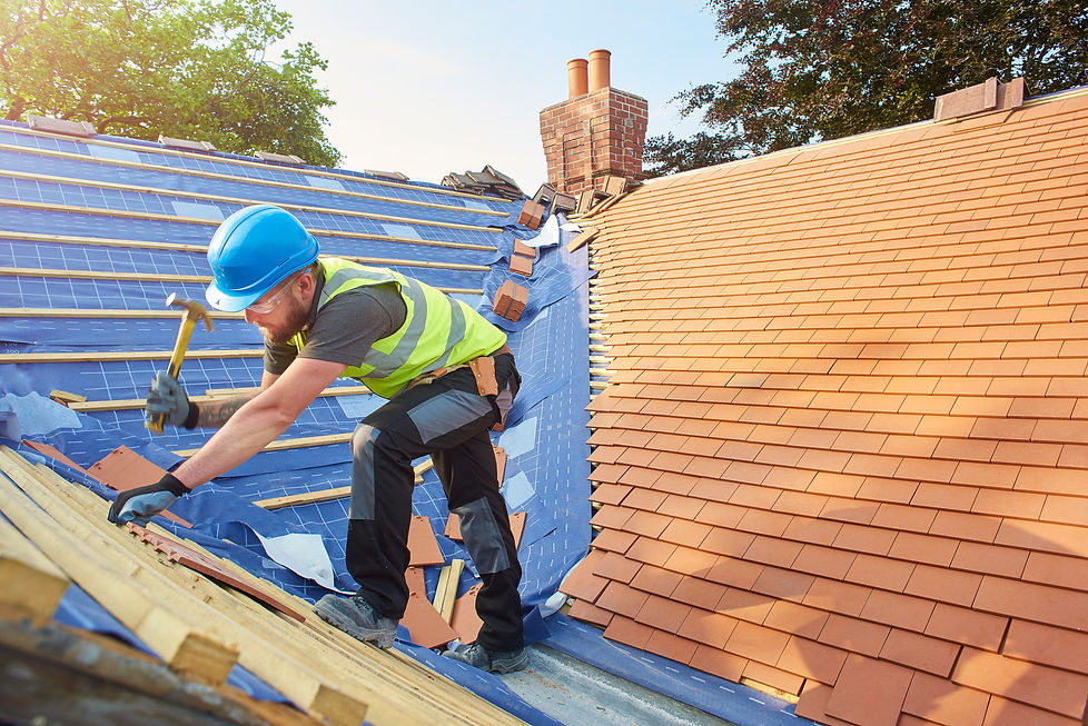 a roofer nails on the roof tiles