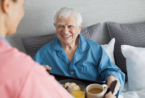 Front view of an elderly man holding food tray