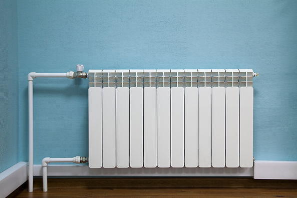 White sectional battery radiator mounted on a light blue wall