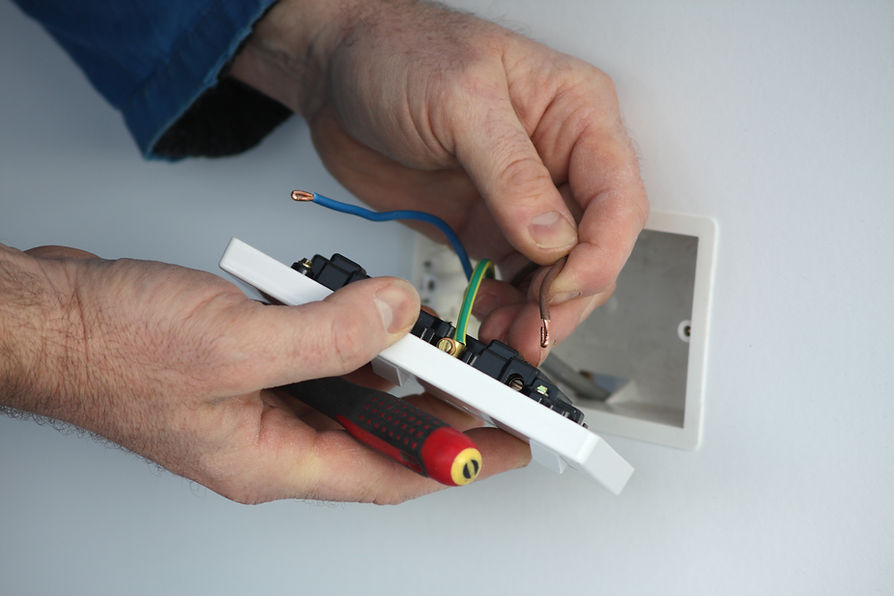 Electrician connecting an electrical socket outlet