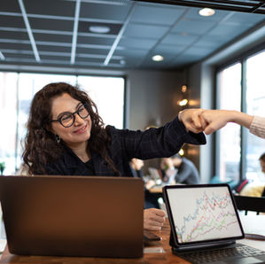two women fist bumping in an office