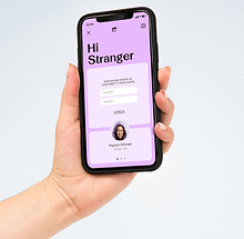 Hand holding up mobile phone with content on screen