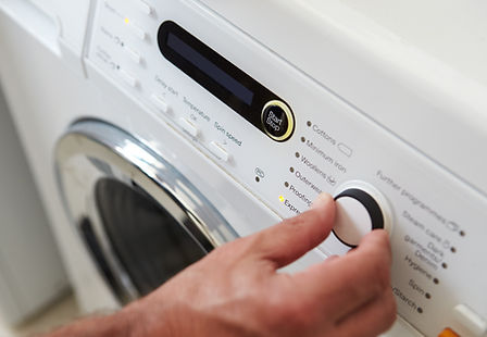 Close-Up Of a person’s hand while Choosing Cycle Program On Washing Machine