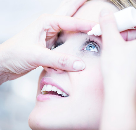 Close-up of person applying eye drops