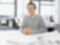 Homme qui sourit assis à un bureau devant des plans