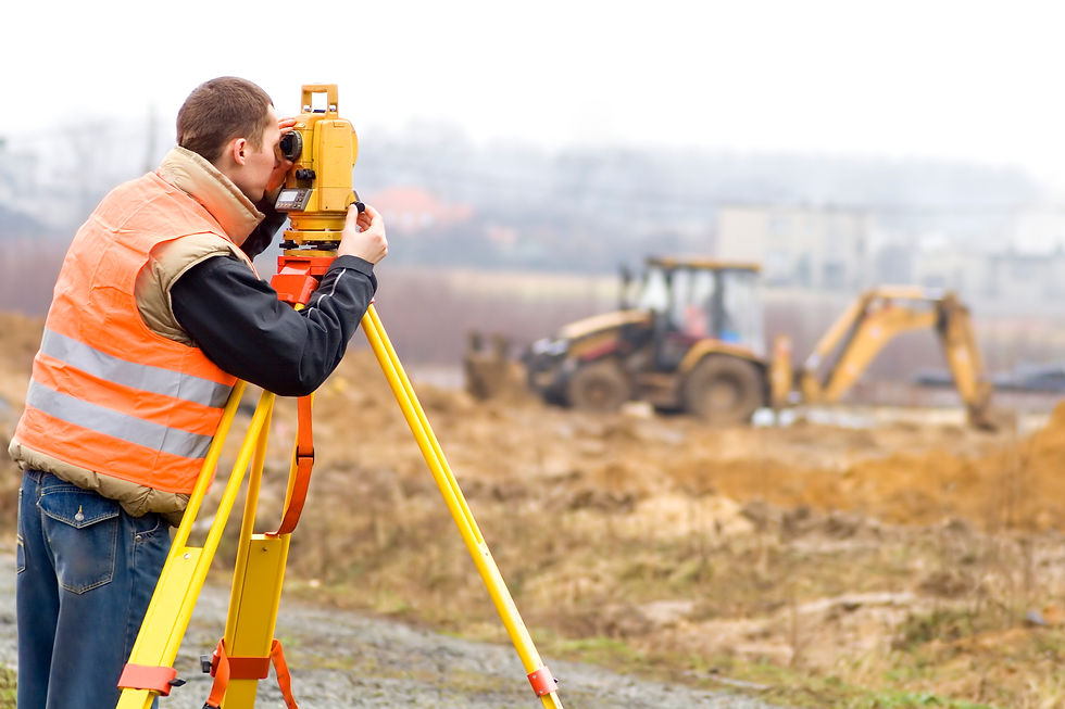 Land surveyor working with total station on a construction site (excavator is beyond depth