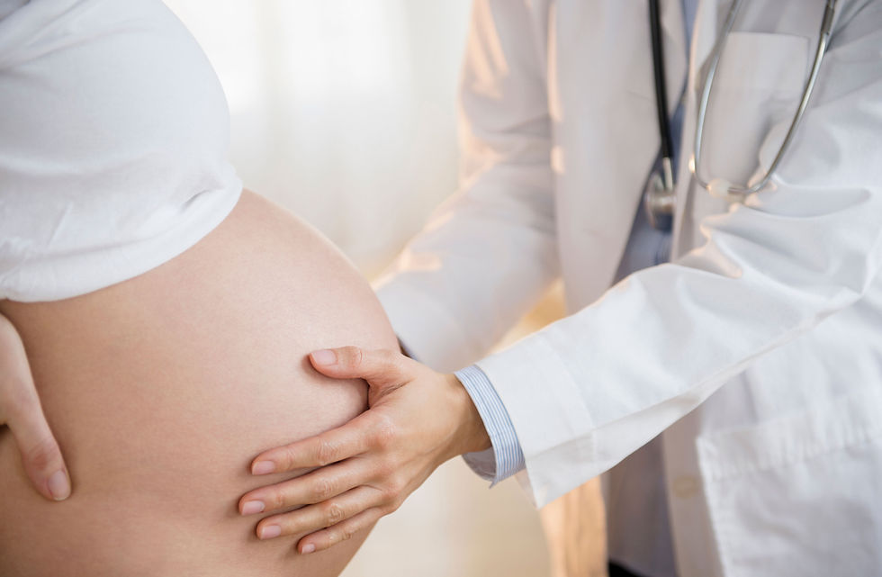 Arzt untersucht Babybauch einer Schwangeren – Impfberatung in der Schwangerschaft