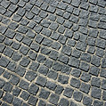 Close-up texture of dark grey granite cobblestone paving