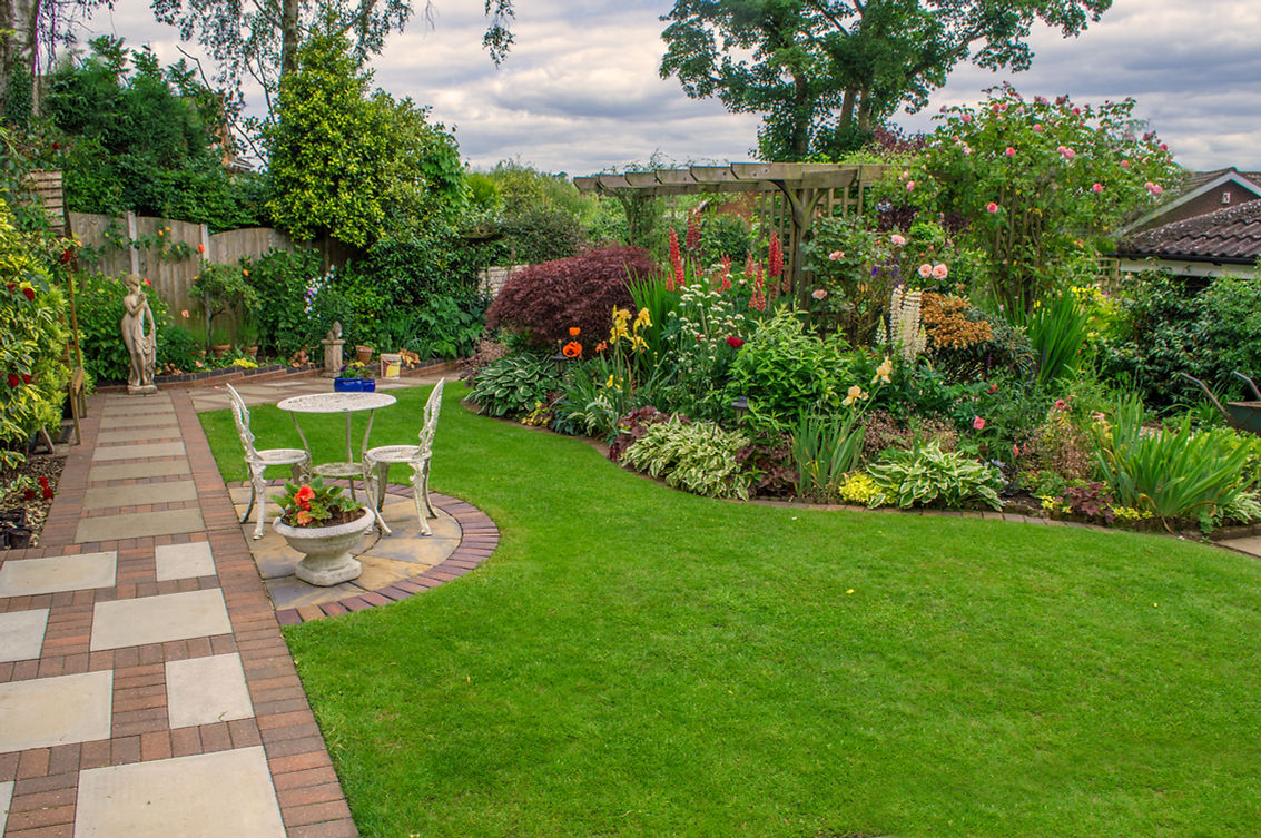 A garden with colourful flowers and a patio