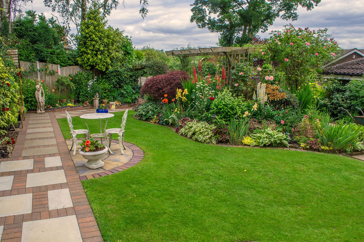 A landscape featuring colourful flowers and a sitting area