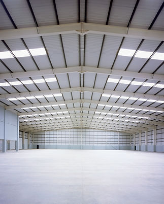 Empty warehouse interior with high ceilings and rows of skylights