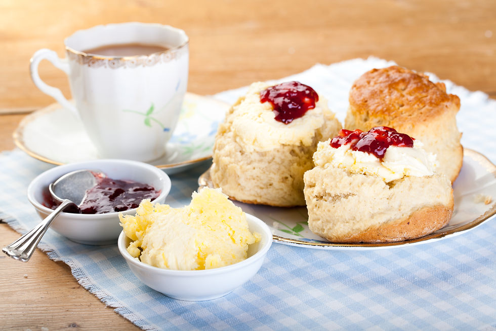 Traditional British cream tea with scones, clotted cream, jam, and a cup of tea