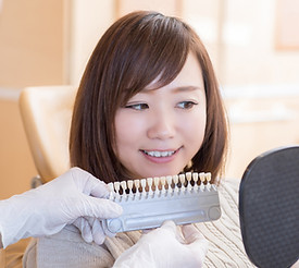 歯の色見本を見る女性