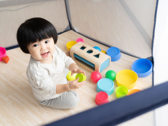 baby playing in play yard