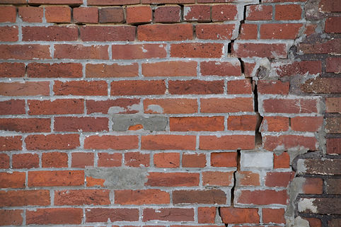 Patched bricks with crumbling mortar in the cracks