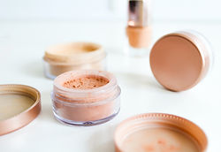 Produits de maquillage ouverts, ambiance douce et féminine