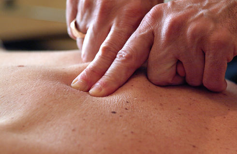 Royalty free photograph of physiotherapist helping patient with back pain UK
