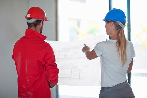 Building contractor and project manager looking at blueprint