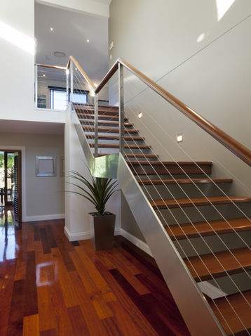 Escalier à limon central en métal avec marches en bois et câbles d’acier, réalisé sur mesure à Sainte-Adèle.
