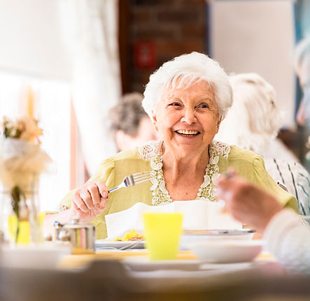 Senior happy having a meal and being taken care of at home.