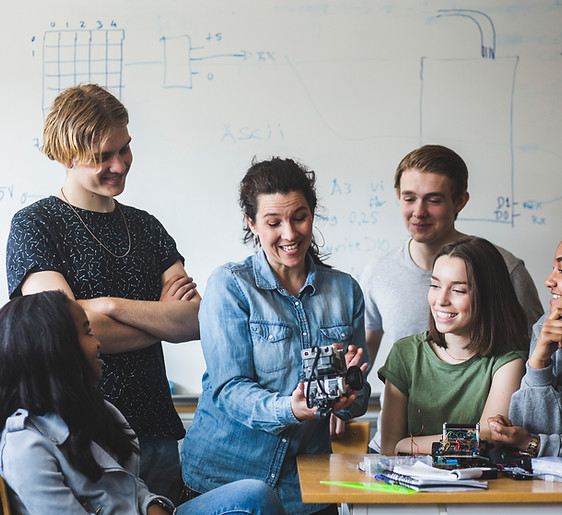 Group of happy teens in a classroom, representing positive mental health outcomes from treatment at Youth-Link Psychiatry