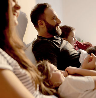 family sitting comfortably on a sofa
