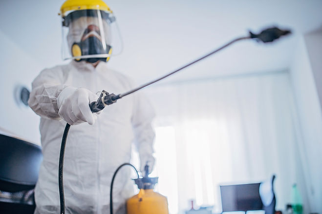 One man, man in protective suit disinfecting office work space alone