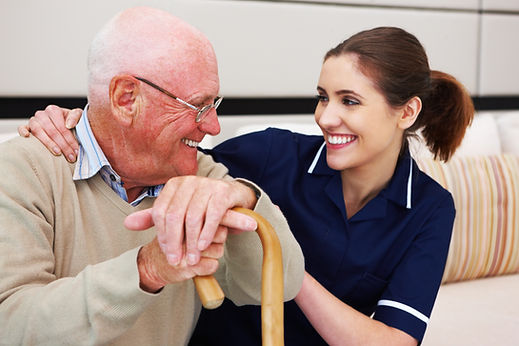 Nurse sits with her arm around an elderly patient