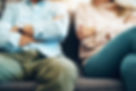 A mature couple sitting on the sofa with their arms folded