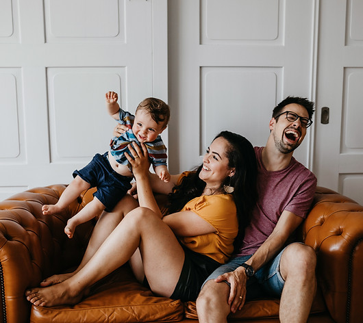 Family laughing on couch
