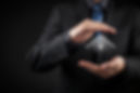 Businessman in a suit cupping hands around a digital house icon, symbolizing protection and security.