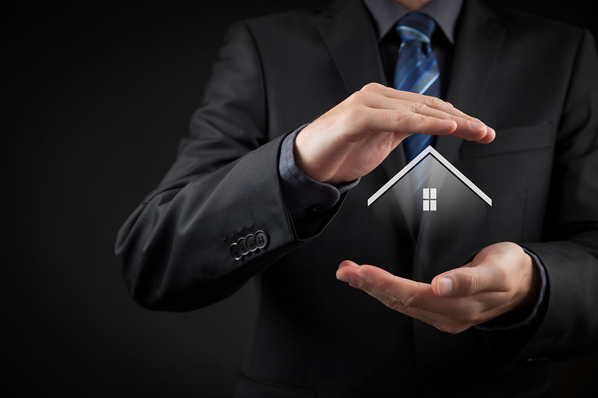 Businessman in a suit cupping hands around a digital house icon, symbolizing protection and security.