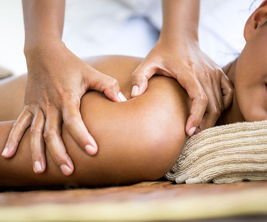 In-home massage setup with linens, oils, and wellness tools