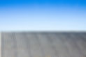 A roof covered in asbestos with a blue sky background