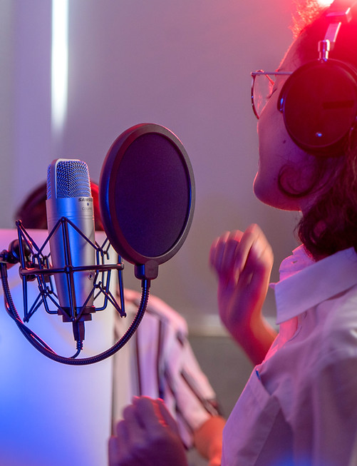 Eine Frau singt in einem Plattenstudio