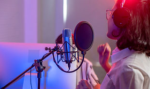 Una mujer cantando en un estudio de grabación