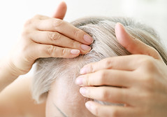 Close up of senior woman examining her hair