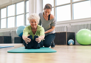 Elderly woman being helped by her instructor
