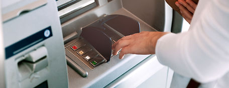 Someone entering their PIN at an ATM