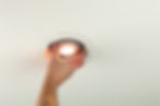 The worker is installing an energy-efficient LED light bulb into a ceiling