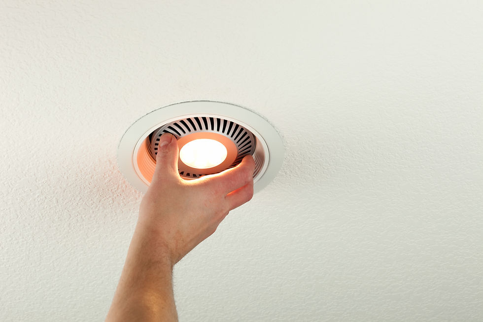 A person is installing a recessed LED downlight into a ceiling fixture