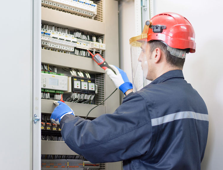 An electrician testing electricity while wearing a red hard hat